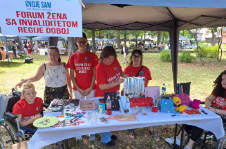 Slika članica Foruma žena s invaliditetom regije Doboj i njihovog štanda sa ručnim radovima tokom sajma “Plodovi sela - domaće je najbolje” u Tesliću, 9. avgusta 2023.