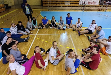 Slika je nastala u sporstkoj sali tokom grupnog rada, čelanovi i članice zajedno sa psihologinjom sjede u krugu na podu sale. Slika je nastala u sporstkoj sali tokom grupnog rada, čelanovi i članice zajedno sa psihologinjom sjede u krugu na podu sale.